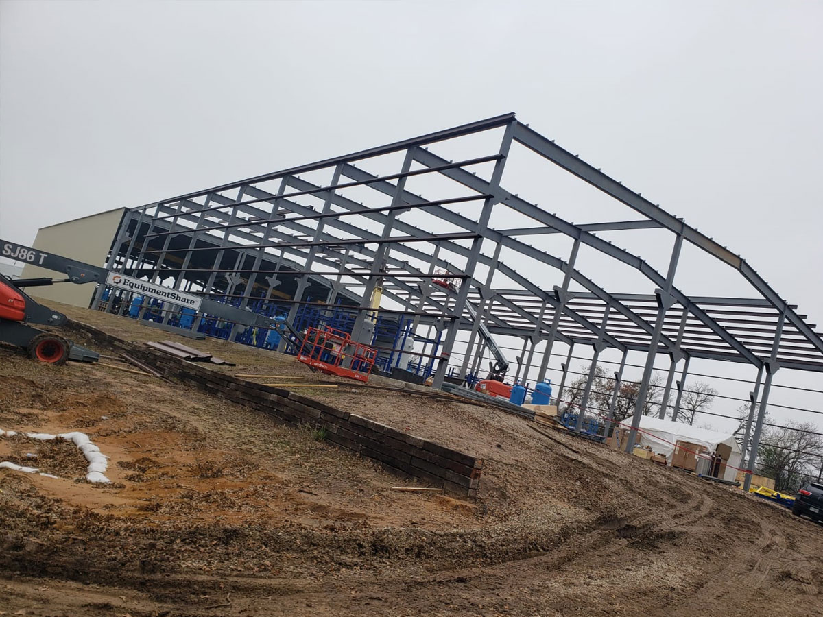 Steel frame structure of a commercial building under construction with equipment on site